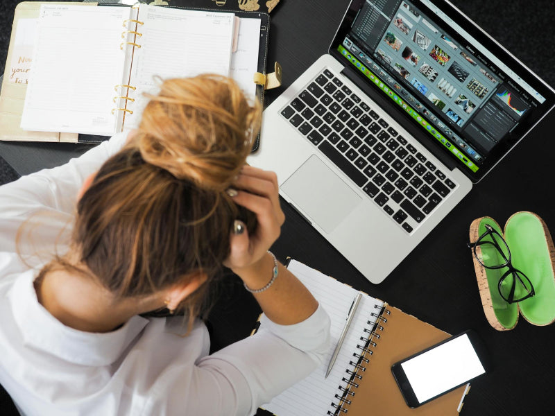 Femme au travail se tenant la tête